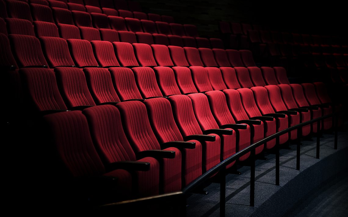 Rows of red seats in a theater by rawpixel com
